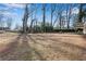 Expansive backyard featuring a fire pit area, bordered by mature trees under a bright sky at 4770 Wayland Cir, Acworth, GA 30101