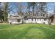 Rear exterior view of the home, showing a fire pit, freshly painted white siding, and a lush green lawn at 4770 Wayland Cir, Acworth, GA 30101