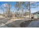 Landscape view of the front yard showing mature trees, gravel, and plants at 4770 Wayland Cir, Acworth, GA 30101