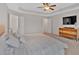 Bright and airy bedroom with tray ceiling, carpet, ceiling fan and light wood furniture at 5528 Donerail St, Lithonia, GA 30058