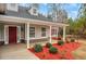 Inviting front porch with red mulch landscaping, and stone accents, perfect for relaxing outdoors at 10 Oakbrook Ln, Covington, GA 30016