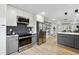 Open kitchen with stainless steel appliances, gray cabinets, white countertops, and herringbone backsplash at 176 Rhodesia Se Ave, Atlanta, GA 30315