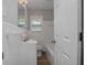 Bathroom with a combination of white tiled walls, tub with shower, and stylish sink vanity at 1857 Dunlap Ave, East Point, GA 30344