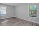 A bright bedroom with light gray walls, wood flooring, and natural light streaming through windows at 1857 Dunlap Ave, East Point, GA 30344