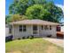 Exterior featuring a lawn, small porch and a blue sky with trees at 1857 Dunlap Ave, East Point, GA 30344