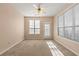 Bright, carpeted bedroom featuring a ceiling fan and two large windows letting in natural light at 3296 Quincey Xing, Conyers, GA 30013