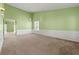 Spacious living room with light green walls, wall trim, and neutral carpet at 3296 Quincey Xing, Conyers, GA 30013