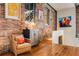 Comfortable living area featuring hardwood floors, exposed brick walls, and classic chair at 500 Means Nw St # F, Atlanta, GA 30318
