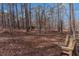 Relaxing backyard retreat with mature trees and charming wooden bench seating to enjoy the natural setting at 1700 Bailey Creek Sw Rd, Conyers, GA 30094