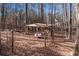 Backyard with a charming covered swing set among the trees, perfect for relaxation at 1700 Bailey Creek Sw Rd, Conyers, GA 30094