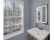 Bathroom featuring a sink with lighted mirror and window views at 1700 Bailey Creek Sw Rd, Conyers, GA 30094