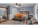 Bright bedroom featuring a queen bed, wood floors, large mirror, and ample natural light from the windows at 1700 Bailey Creek Sw Rd, Conyers, GA 30094