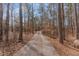 Extended driveway through a mix of deciduous and evergreen trees leading up to the residence at 1700 Bailey Creek Sw Rd, Conyers, GA 30094