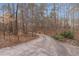 Long, paved driveway leading through a wooded landscape to the property at 1700 Bailey Creek Sw Rd, Conyers, GA 30094