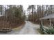 Long concrete driveway leading to the house with a wooded area, and an American flag displayed at 1700 Bailey Creek Sw Rd, Conyers, GA 30094