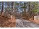 Tree-lined driveway with a wooden fence, leading to the home at 1700 Bailey Creek Sw Rd, Conyers, GA 30094