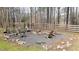 Outdoor fire pit area with gravel base, rock border, and surrounded by wooden Adirondack chairs and fence at 1700 Bailey Creek Sw Rd, Conyers, GA 30094