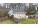 Detached two-car garage featuring white siding, a dark roof, and a paved driveway with a wooden fence at 1700 Bailey Creek Sw Rd, Conyers, GA 30094