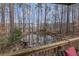 View of backyard pond with surrounding trees from an outdoor deck at 1700 Bailey Creek Sw Rd, Conyers, GA 30094