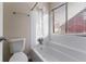 Clean, white tiled bathtub and shower combination with natural light at 994 Chapman Cir, Stone Mountain, GA 30088