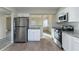 Modern kitchen with stainless steel appliances, granite counters, and a view into the adjacent room at 994 Chapman Cir, Stone Mountain, GA 30088