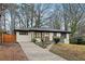 Ranch home with a concrete driveway, and a well-manicured front yard with mature trees at 1090 Indale Sw Pl, Atlanta, GA 30310