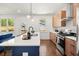 Well-lit kitchen with wood cabinets, white countertops, and a blue island open to living area at 1183 Mobile Nw St, Atlanta, GA 30314