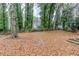 Large, leaf-covered backyard with mature trees and chain-link fence, offering privacy and outdoor space at 1850 Brewer Sw Blvd, Atlanta, GA 30310