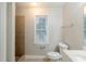 Bathroom featuring a walk-in shower with brown tile and white fixtures at 1850 Brewer Sw Blvd, Atlanta, GA 30310