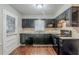 Functional kitchen featuring dark cabinets, wood laminate flooring, and stainless steel appliances at 1850 Brewer Sw Blvd, Atlanta, GA 30310