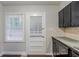 Well-lit kitchen space featuring dark cabinets, stainless steel appliances, laminate floors, and a white back door at 1850 Brewer Sw Blvd, Atlanta, GA 30310