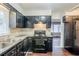 Functional kitchen featuring dark cabinets, wood laminate flooring, and stainless steel appliances at 1850 Brewer Sw Blvd, Atlanta, GA 30310