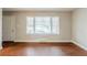 Bright living room featuring wood floors, neutral walls, a large window and a white front door at 1850 Brewer Sw Blvd, Atlanta, GA 30310