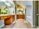 Long bathroom featuring double vanities, tile floors, and an alcove bathtub and glass shower at 3135 Preservation Cir, Lilburn, GA 30047