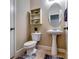 Powder room featuring pedestal sink, oval mirror, wall cabinet and neutral color palette at 3135 Preservation Cir, Lilburn, GA 30047