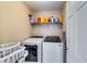 Functional laundry room with a washer, dryer, and shelving unit at 3135 Preservation Cir, Lilburn, GA 30047