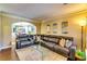 Relaxing living room featuring a sectional sofa and an open view into the dining room at 3135 Preservation Cir, Lilburn, GA 30047