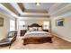 Well-lit main bedroom featuring a tray ceiling, plush carpet, and a stately bed at 3135 Preservation Cir, Lilburn, GA 30047