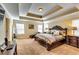 Serene main bedroom featuring a tray ceiling, soft carpet, and a stately wood-framed bed at 3135 Preservation Cir, Lilburn, GA 30047