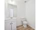 Bright bathroom featuring a modern vanity, a large mirror, and a toilet with wood-look flooring at 6474 E Meyer Dr, Morrow, GA 30260