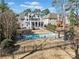 Aerial backyard view of private pool, patio area, green space, and rear house elevation at 1034 Fairview Club Cir, Dacula, GA 30019