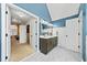 Bathroom with blue accent wall, white hexagonal tile floor, and doorway to bedroom and walk-in closet at 1034 Fairview Club Cir, Dacula, GA 30019