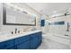 Modern bathroom featuring double sinks with blue cabinets, quartz counters and shower with glass door at 1034 Fairview Club Cir, Dacula, GA 30019