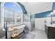 Bright bathroom featuring a soaking tub under a large arched window and a glass-enclosed shower at 1034 Fairview Club Cir, Dacula, GA 30019