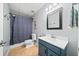 Compact bathroom featuring tiled floors, a vanity, toilet, and a shower with a blue curtain at 1034 Fairview Club Cir, Dacula, GA 30019