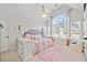 Bright bedroom with a large arched window, plush bedding, and cozy seating area at 1034 Fairview Club Cir, Dacula, GA 30019