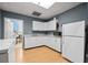 Bright kitchenette with white cabinetry, laminate flooring, and stainless steel appliances at 1034 Fairview Club Cir, Dacula, GA 30019