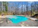 Backyard view of private pool with diving board, poolside furniture, and landscaped surroundings at 1034 Fairview Club Cir, Dacula, GA 30019