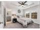 Bedroom featuring a tray ceiling, a ceiling fan, a window, carpet floors, and ensuite bathroom at 3320 Reagan Way # 80, Lawrenceville, GA 30044