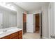 Neutral bathroom featuring a wood vanity, large mirror, and tiled flooring at 982 Ashton Park Dr, Lawrenceville, GA 30045